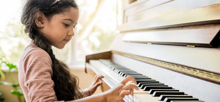 Girl playing piano while learning music.